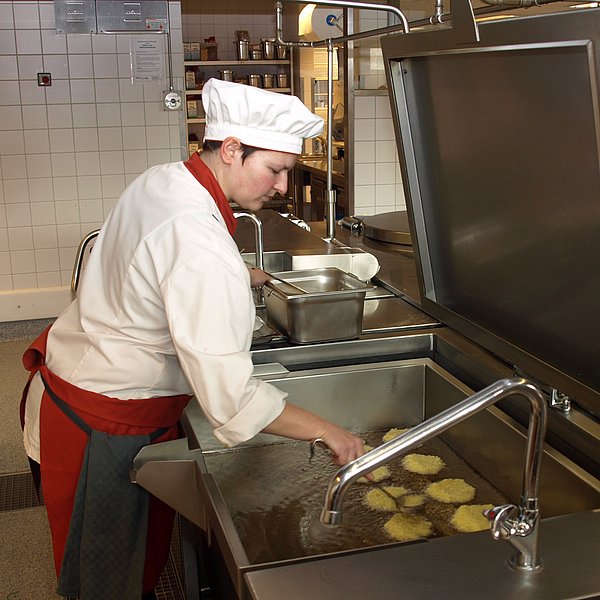 Köchin in der hauseigenen Küche des Hufeland-Hauses, beim Frittieren