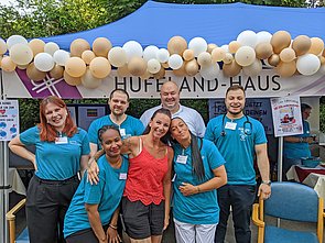 Azubis des Hufeland-Hauses, lächelnd vor einem Pavillon mit vielen Luftballons